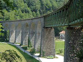 The Idrijca Viaduct runs in an elegant arch high above the main road and the Idrijca River. The Idrijca Viaduct runs in an elegant arch high above the main road and the Idrijca River.